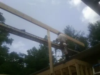 Carpenter setting a ridge beam over a new addition frame — Ice Dam Removal by Roofing Brothers in Mine Hill