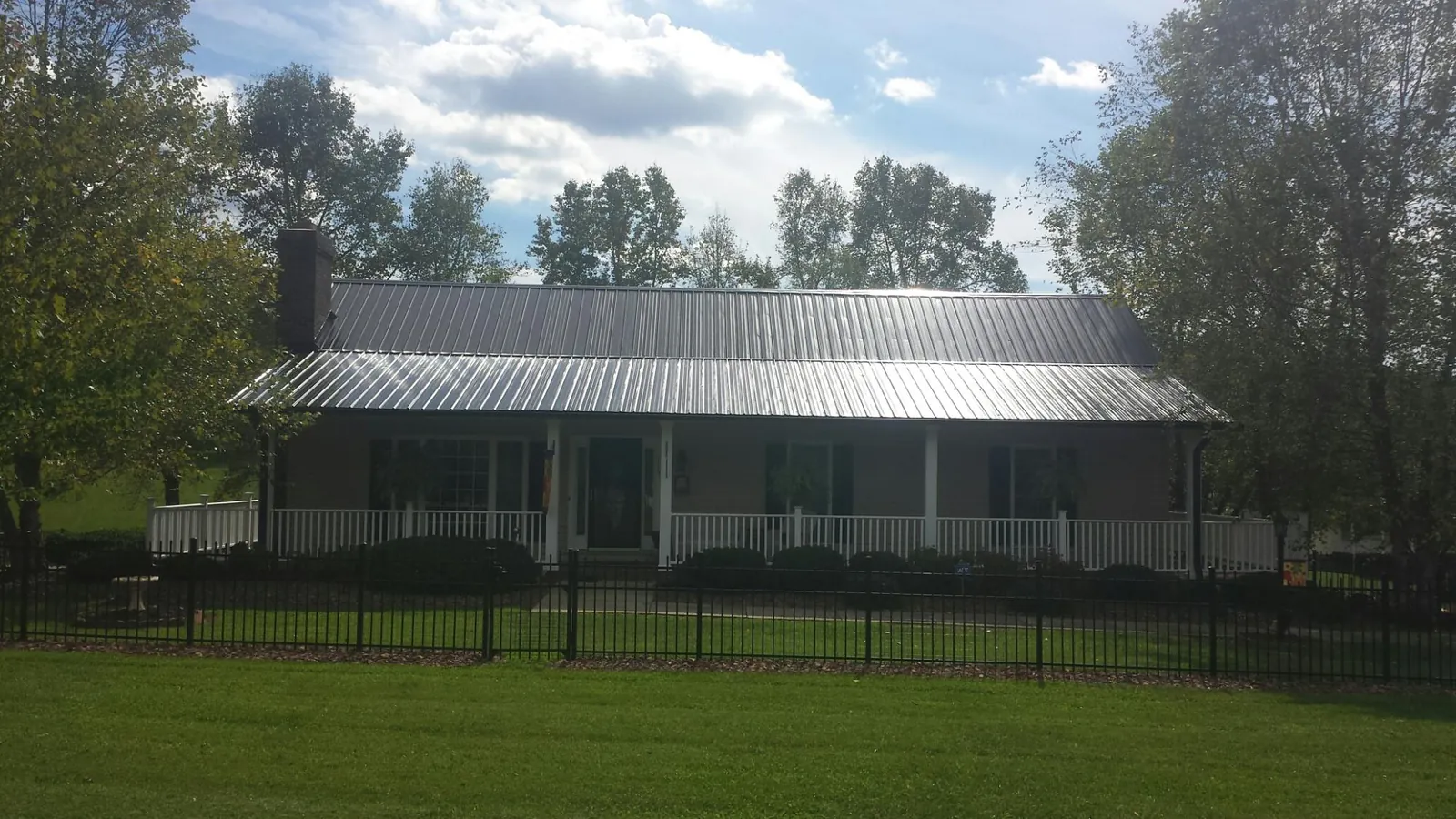 Gray metal roof on a brick ranch with a full width front porch — Gutter Guard Installation work by our crew in Mine Hill