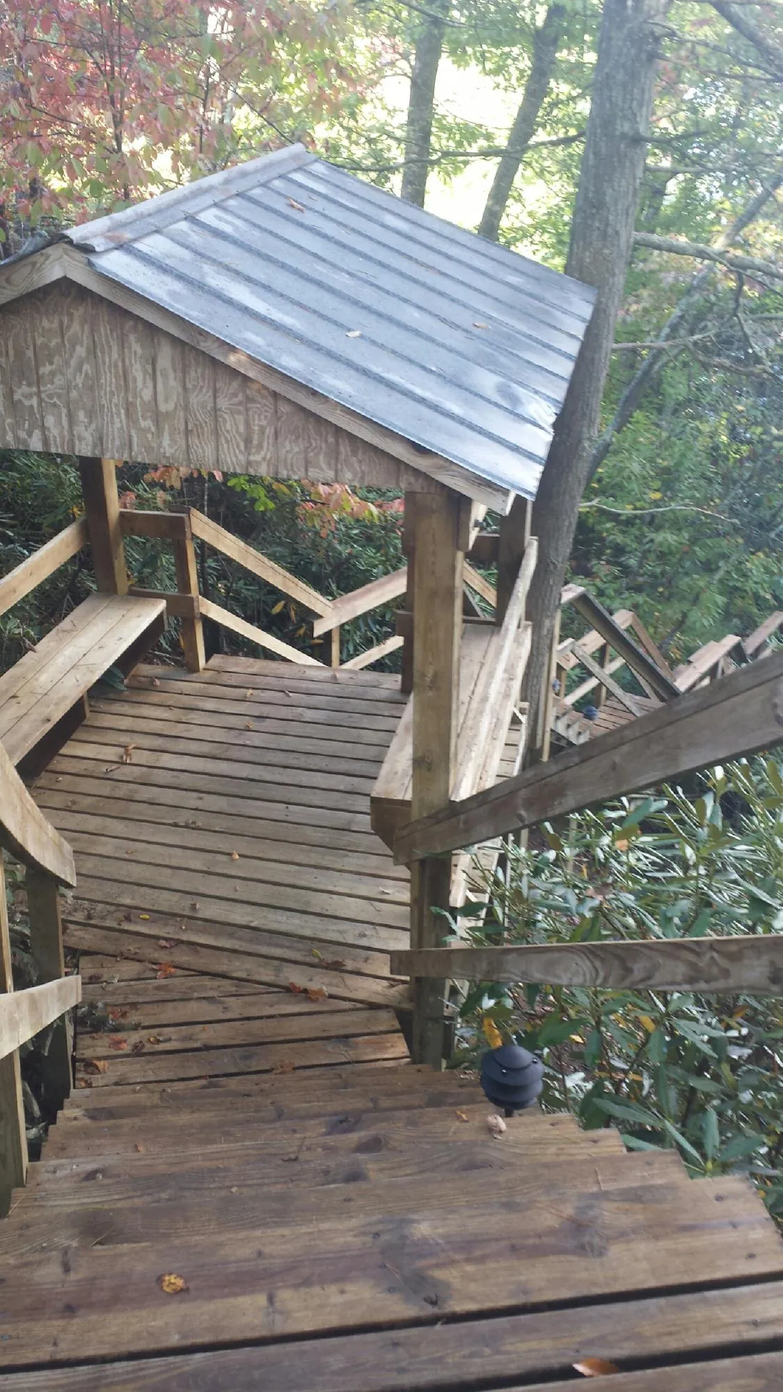 Metal roofed shelter over wooden steps on a wooded walkway — Skylight Repair & Installation work by our crew in Mine Hill